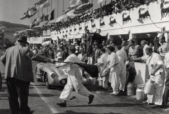 Arrêt au stand pour la n°104. Alfred Neubauer, directeur de course chez Mercedes, au premier plan, tenant le drapeau.